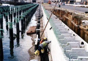Workers Examining Side of Pier Installation
